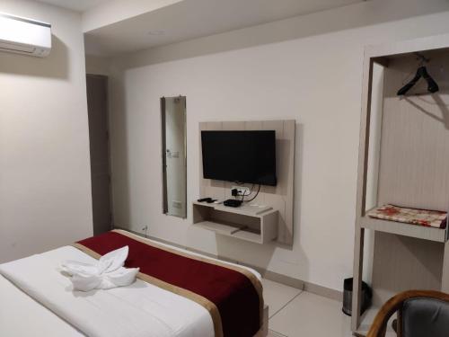 a hotel room with a bed and a television at Hotel Hamilton in Zirakpur