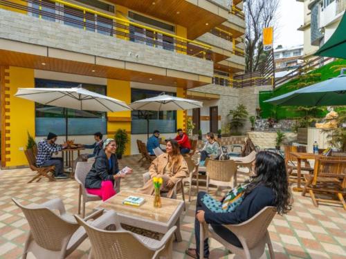 a group of people sitting at an outdoor restaurant at The Hosteller Mcleodganj, Bhagsu in McLeod Ganj