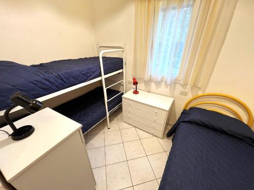 a bedroom with two beds and a desk with a lamp at Villa Duna Nord 287 in Bibione