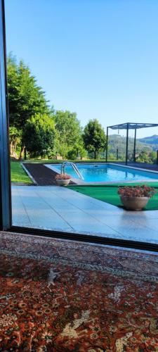 a view of a swimming pool through a window at CASA das Leiras in Vieira do Minho