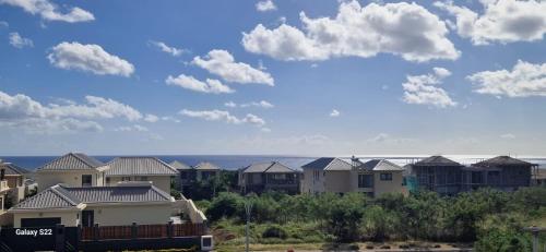 a row of houses with the ocean in the background at Ocean Views & Stunning Sunsets 1st-Floor Villa in Flic-en-Flac