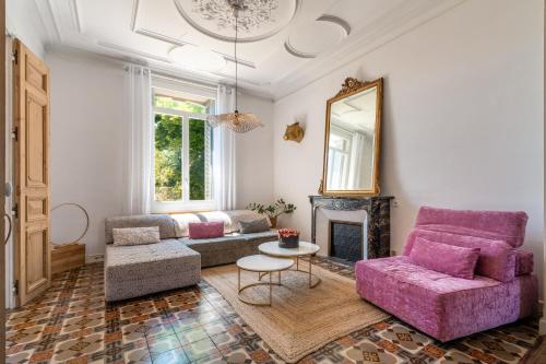 - un salon avec un canapé rose et une cheminée dans l'établissement Coeur Cristal - Maison de maître & Ecolodge avec piscine et jardin, à Magalas