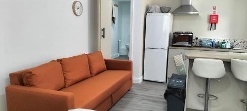 a living room with a couch and a kitchen at Blue Moon Self Catering Accommodation in Dunkineely
