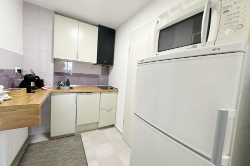 a kitchen with white cabinets and a white refrigerator at Dora Holiday House & Apartments in Keszthely