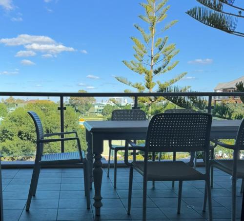 a table and chairs on a balcony with a tree at Mandurah Marina Serenity in Mandurah