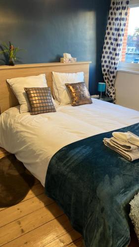 Una cama grande con almohadas en una habitación. en Maison Corneille proche de Lille, en Hem