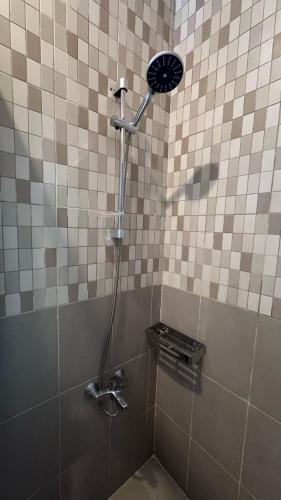 a shower with a shower head in a bathroom at يزن للاجنحة الفندقية in Aqaba