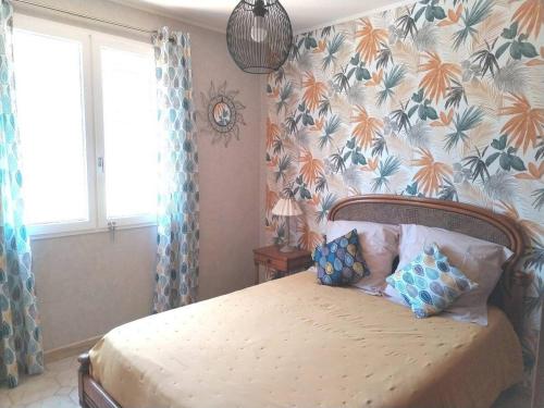 une chambre avec un lit avec des oreillers bleus dessus dans l'établissement Lumineuse villa au pied de la pinède, à Lézignan-Corbières