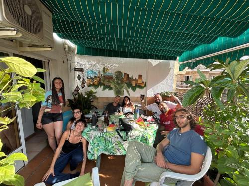 a group of people sitting around a table on a patio at Hostel El Cascabel in Granada