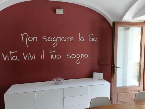 a room with a red wall with writing on the wall at La petite maison Fleur in Biella
