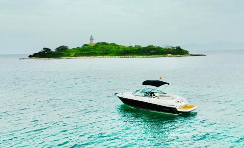 a boat in the water with a lighthouse in the background at Mallorcainblue Charter in Port d'Alcudia