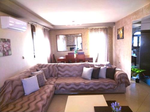 a large leather couch in a living room with a table at Rias house in Néa Péramos