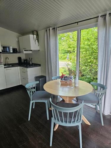 a kitchen and dining room with a table and chairs at Woodcabin op de Lente van Drenthe in Gasselte