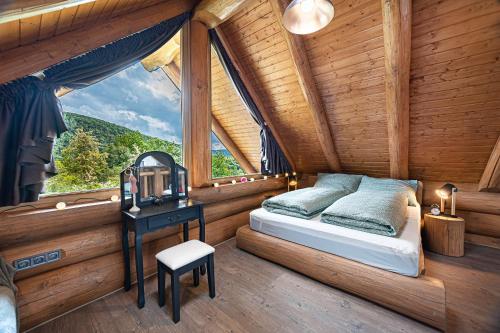 a bedroom in a log cabin with a bed and a table at Bándi Kuckó in Bánd