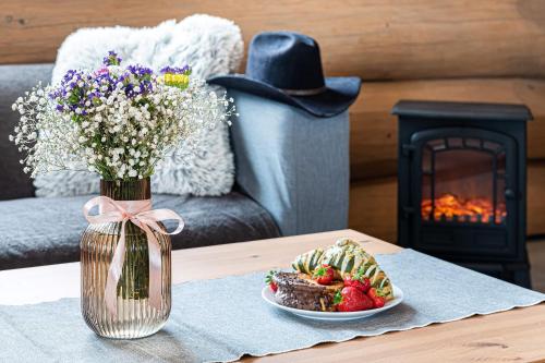 a table with a vase of flowers and a plate of food at Bándi Kuckó in Bánd