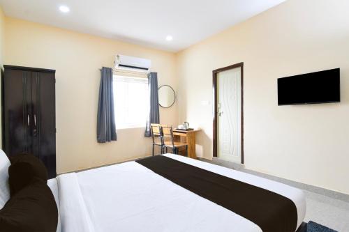 une chambre avec un lit et une télévision à écran plat dans l'établissement Townhouse VSK group of hotels, à Hyderabad