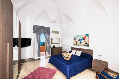 una camera con letto blu e TV di Villa Setteventi a Positano