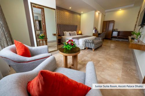 a hotel room with a bed and two couches at Ascott Palace Dhaka in Dhaka