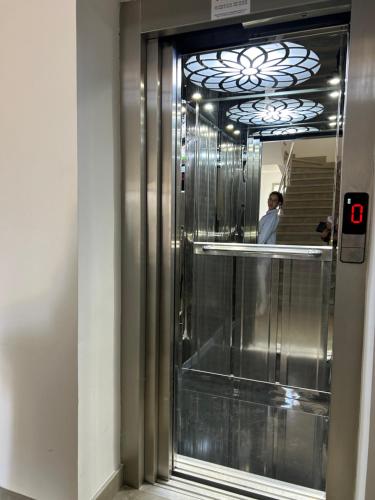 a man walking down an elevator in a building at Appartement haut standing jardins Assilah in Asilah