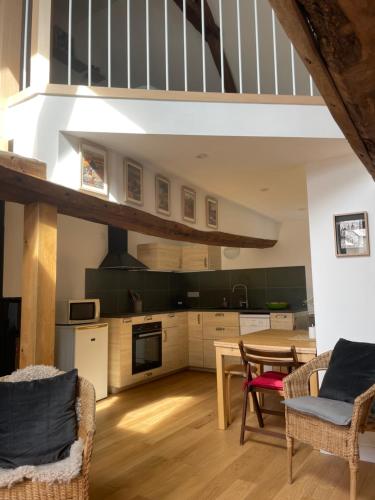une cuisine avec une table et des chaises ainsi qu'un escalier dans l'établissement Peaceful countryside loft, à Saonnet