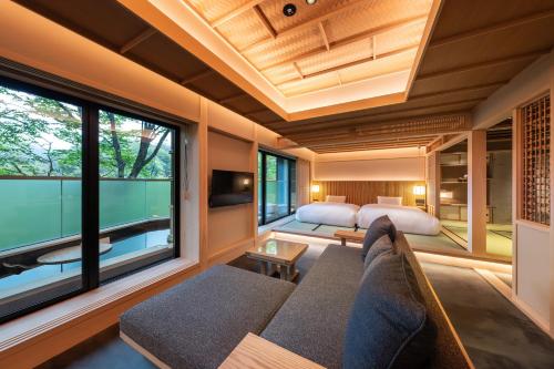 a living room with a couch and a large window at Nazuna Hakone Miyanosita in Miyanoshita