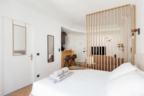 - une chambre blanche avec un grand lit et des draps blancs dans l'établissement Stylish renovated studio near the Palais, à Cannes