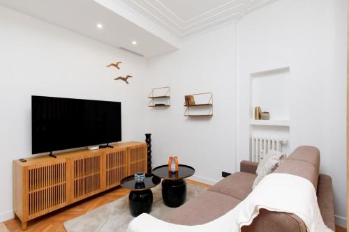 un salon avec un canapé et une télévision à écran plat dans l'établissement Stylish renovated studio near the Palais, à Cannes