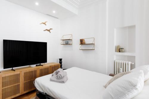 - une chambre avec une télévision à écran plat et un lit dans l'établissement Stylish renovated studio near the Palais, à Cannes