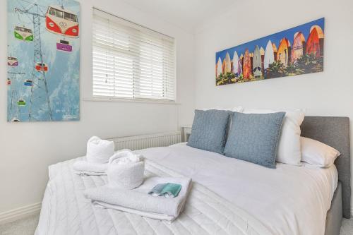 Un dormitorio con una cama blanca con toallas. en Quiet Mews House with PARKING and GARDEN close to centre and beach, en Brighton & Hove