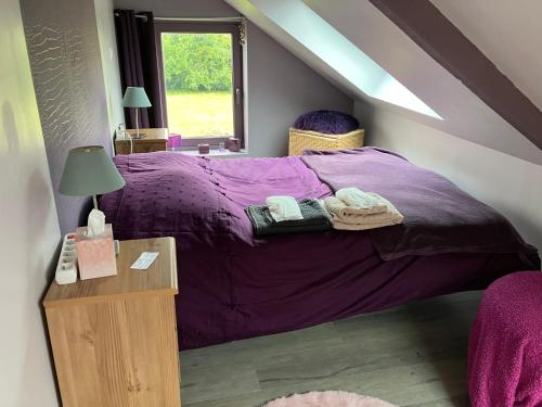 1 dormitorio con cama morada y mesa en Maison Corneille proche de Lille, en Hem
