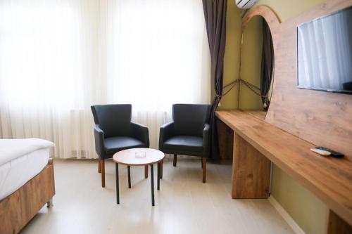 a room with two chairs and a table and a mirror at Altayhan Otel in Amasya