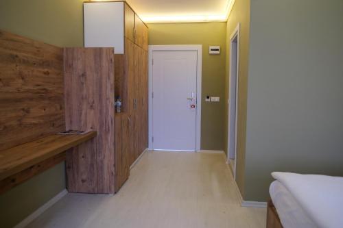 a bedroom with a white door and a wooden wall at Altayhan Otel in Amasya