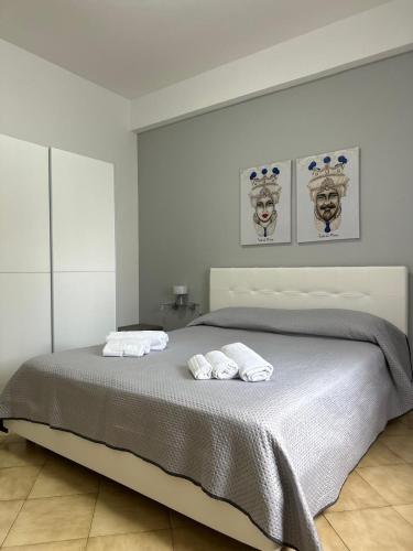 a bedroom with a bed with two towels on it at Naxos Sweet Dreams Apartment in Giardini Naxos