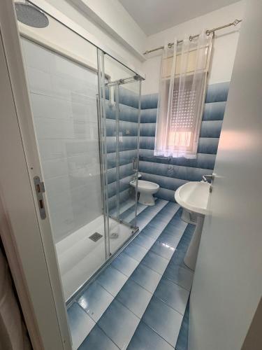 a bathroom with a shower and a toilet and a sink at Naxos Sweet Dreams Apartment in Giardini Naxos