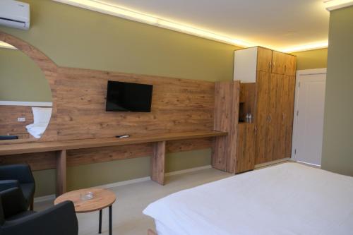 a room with a bed and a tv on a wall at Altayhan Otel in Amasya