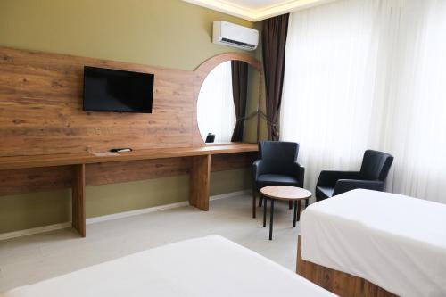 a hotel room with a desk with a tv and two chairs at Altayhan Otel in Amasya