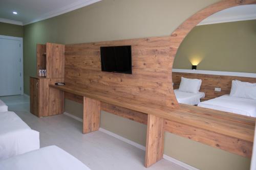 a room with two beds and a tv on a wall at Altayhan Otel in Amasya