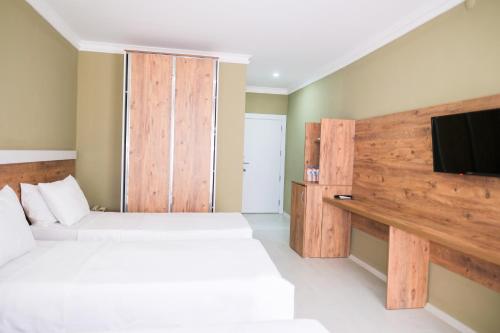 a bedroom with two beds and a flat screen tv at Altayhan Otel in Amasya