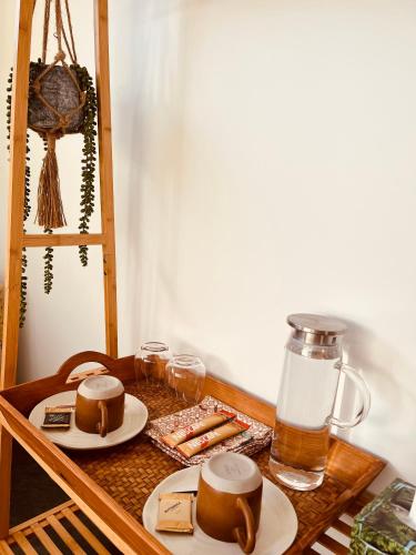 a wooden table with two plates of food and a drink at Cozy Private Room in New Home in Raglan