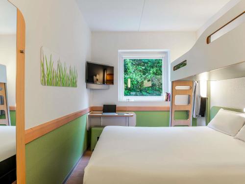 ein Schlafzimmer mit einem Bett, einem Schreibtisch und einem Fenster in der Unterkunft Ibis Budget Bilbao Barakaldo in Barakaldo