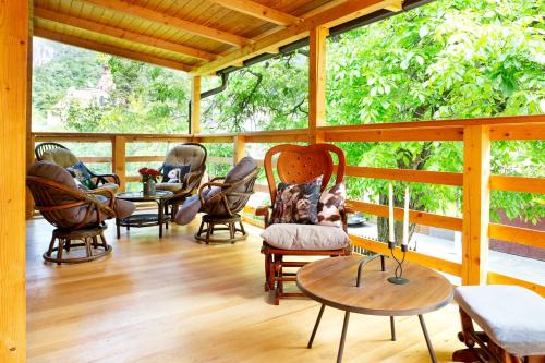 a screened in porch with chairs and a table at Casa Decebal in Băile Herculane