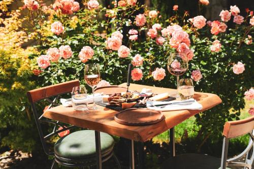 a wooden table with wine glasses and a plate of food at Bengodi Boutique Hotel in Eceabat