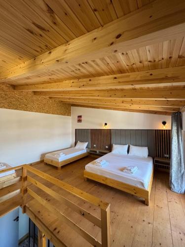 two beds in a room with wooden ceilings at Sea's Villa in Ksamil