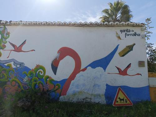 a wall with a painting of a swan on it at Quinta da Fornalha - Santuario Agroecologico in Castro Marim