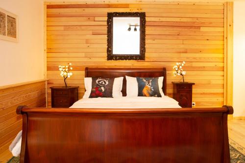 a bed in a room with a wooden wall at Casa Decebal in Băile Herculane