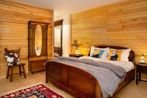 a bedroom with a large bed with a wooden wall at Casa Decebal in Băile Herculane