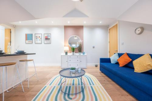 a living room with a blue couch and a table at 2 Bed Apartment - Cardiff City Centre - Free Parking in Cardiff
