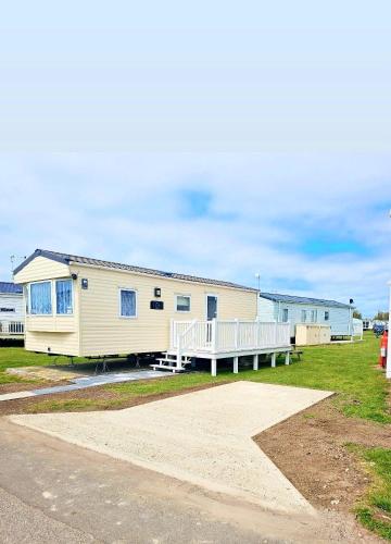 a row of mobile homes on the side of a road at Magic Caravan Camber Sands in Camber