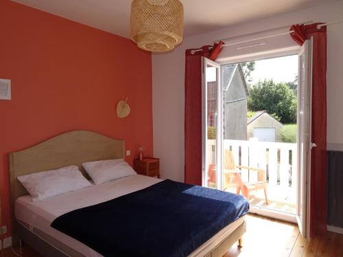 une chambre avec un lit et une porte coulissante en verre dans l'établissement 5 min de la mer à pied, jolie maison des années 30, à Saint-Quay-Portrieux