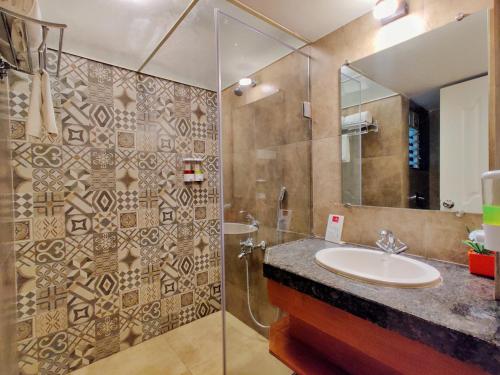 a bathroom with a sink and a shower at Pushpam Sanskruti Resort Karjat- Pure Veg in Karjat
